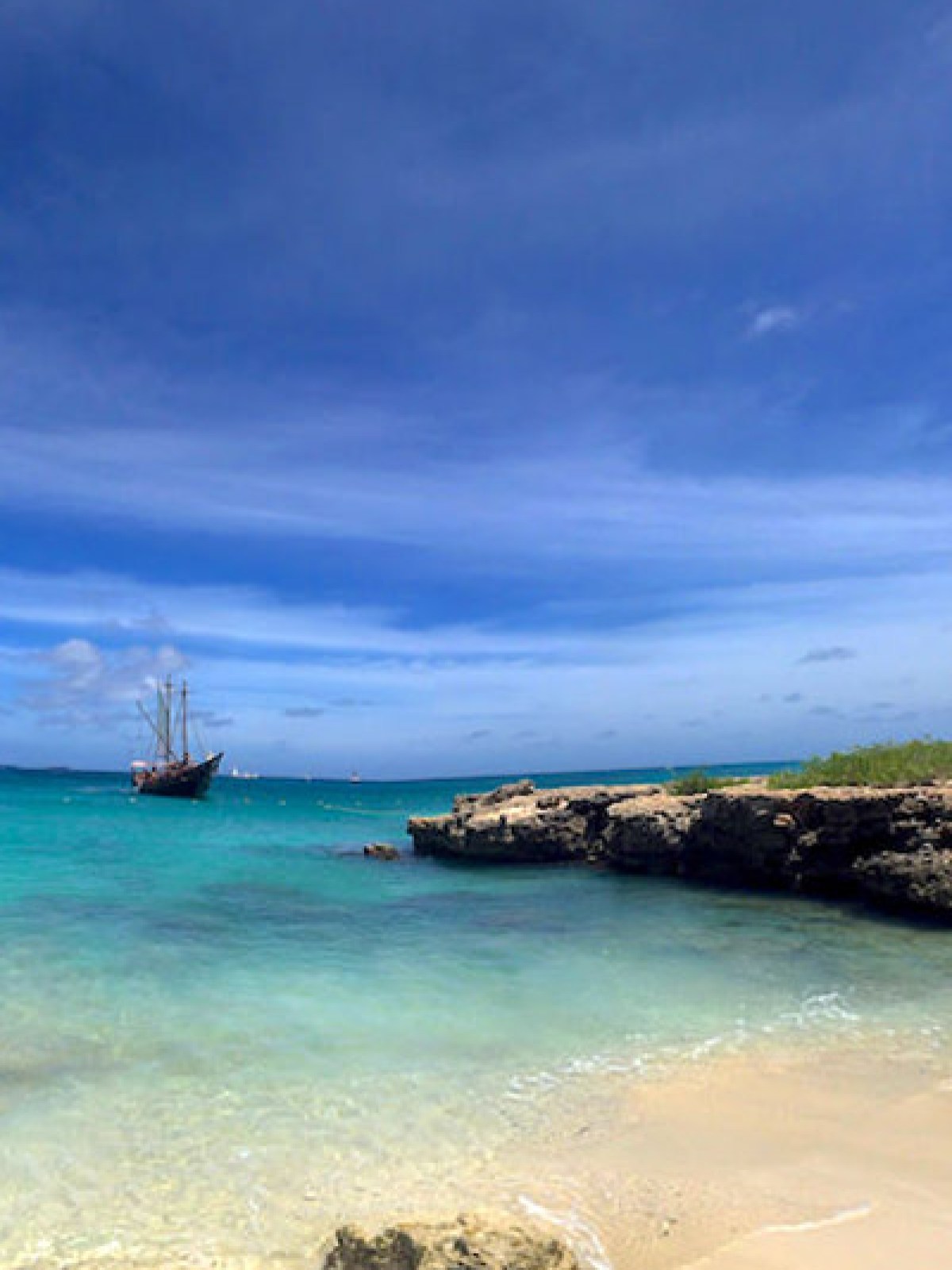 a boat sitting on top of a beach next to a body of water
